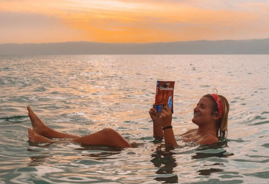 the-girl-reading-book-and-enjoying-her-dad-sea-trip-in-jordan